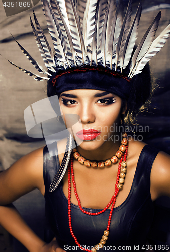 Image of young pretty woman with make up like red indian, futher in hair,