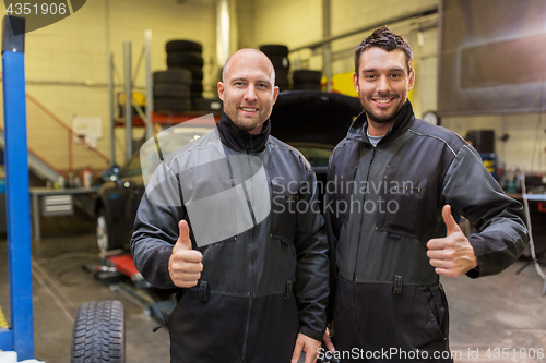 Image of auto mechanics or tire changers at car shop