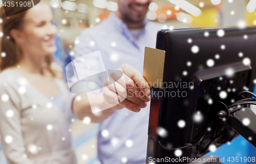 Image of couple with customer card at store self-checkout