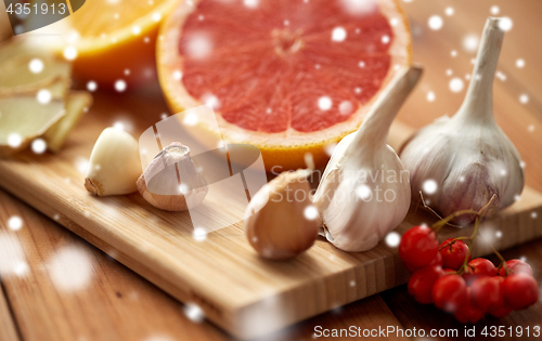 Image of citrus, ginger, garlic and rowanberry on wood