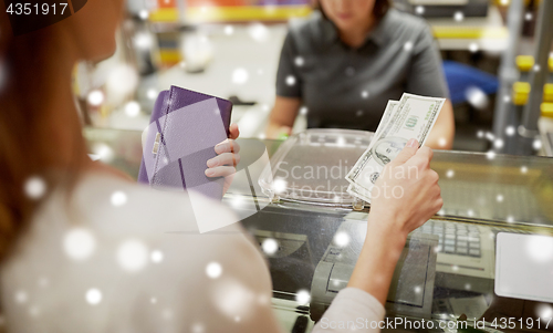 Image of woman paying money at store cash register