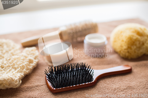 Image of hair brush, cream, sponge, soap bar and bath towel