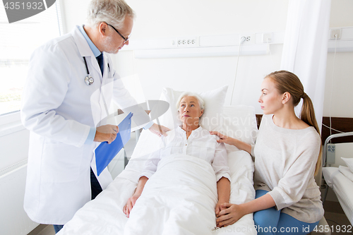 Image of senior woman and doctor with clipboard at hospital