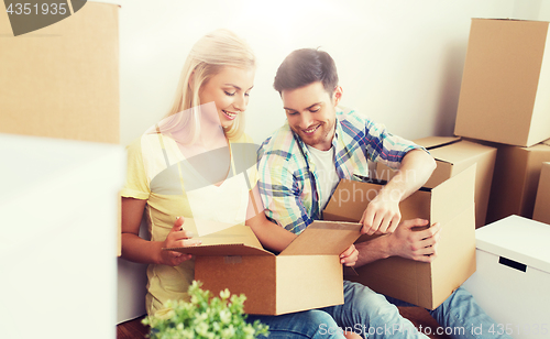 Image of smiling couple with many boxes moving to new home