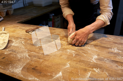 Image of baker making bread dough at bakery kitchen