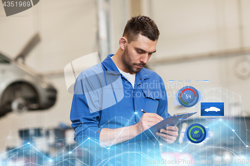 Image of auto mechanic man with clipboard at car workshop