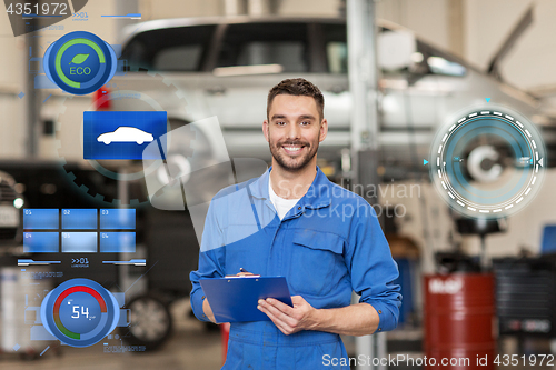 Image of happy mechanic man with clipboard at car workshop