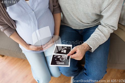 Image of close up of couple with baby ultrasound images