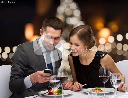 Image of smiling couple eating main course at restaurant