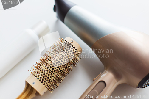 Image of hairdryer, brush and hot styling hair spray