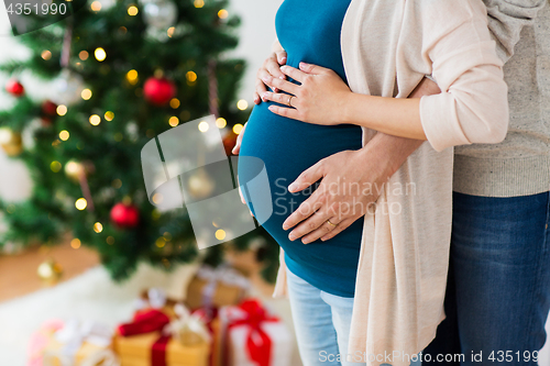 Image of man and pregnant woman home at christmas