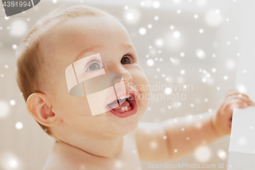 Image of face of happy little baby boy or girl looking up