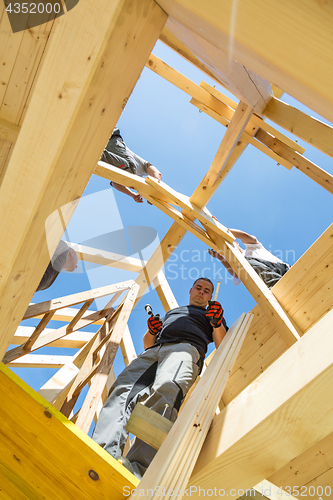 Image of Builders at work with wooden roof construction.