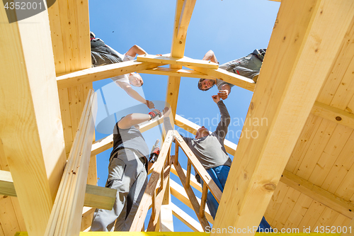 Image of Builders at work with wooden roof construction.