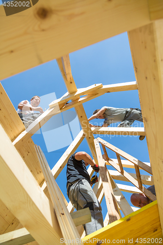 Image of Builders at work with wooden roof construction.