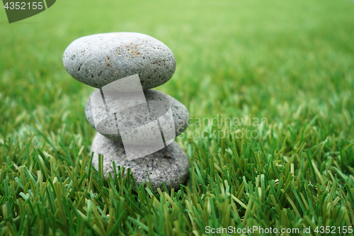 Image of Pebbles stacked up on grass