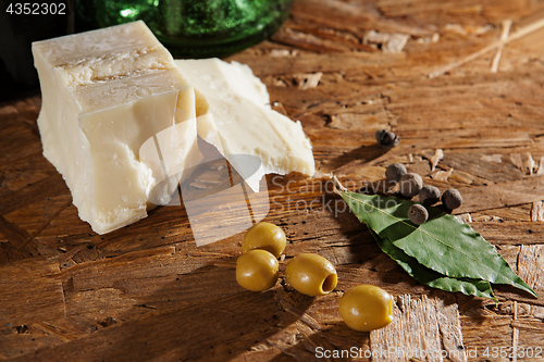 Image of cheese and olives on wooden surface