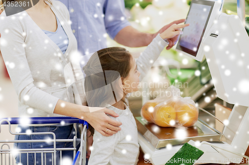 Image of family weighing oranges on scale at grocery store