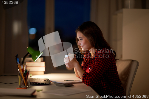 Image of student woman with laptop and coffee at night home