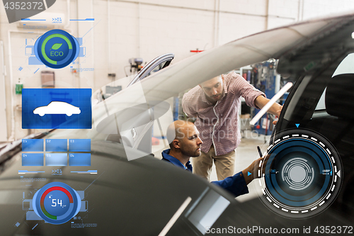 Image of mechanic and man checking seat belt at car shop