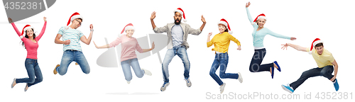 Image of happy people in santa hats jumping in air