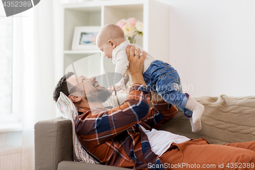 Image of happy father with little baby boy at home