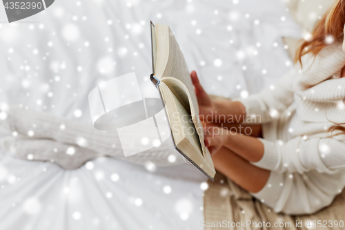 Image of close up of young woman reading book at home