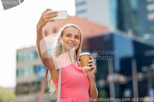 Image of woman with coffee taking selfie by smartphone