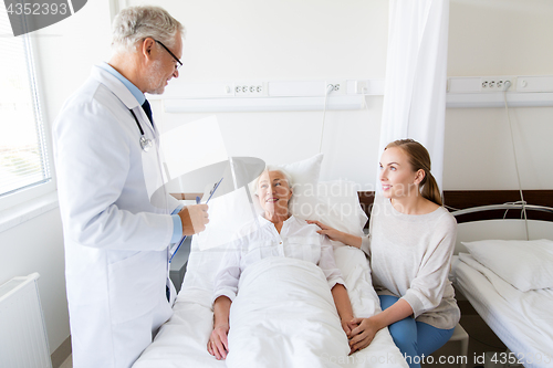 Image of senior woman and doctor with clipboard at hospital