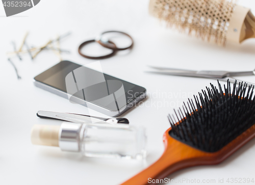 Image of smartphone, scissors, brushes and other hair tools