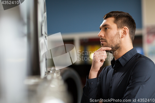 Image of male customer choosing wheel rims at car service