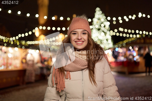 Image of happy young woman at christmas market in winter