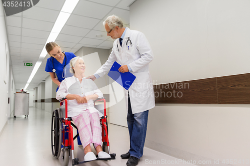 Image of medics and senior patient in wheelchair at clinic