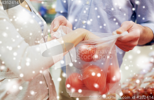 Image of close up of couple with tomatoes at grocery store