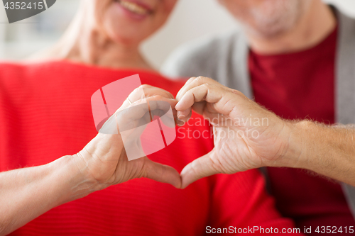 Image of close up of senior couple showing hand heart sign