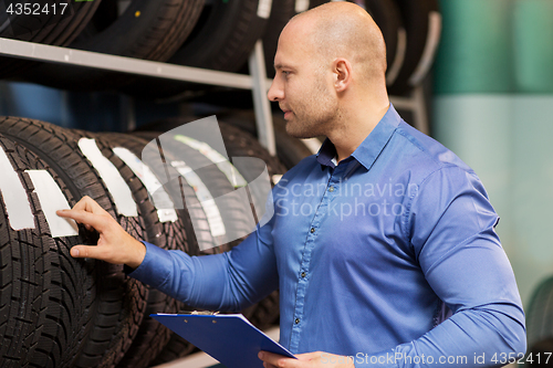 Image of auto business owner and wheel tires at car service