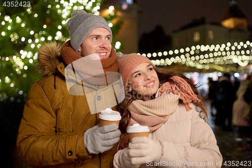 Image of happy young couple with coffee at christmas market