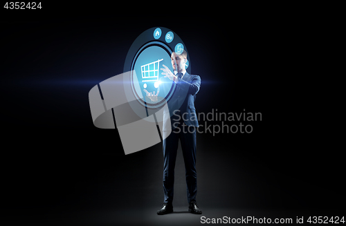 Image of businessman with shopping cart on virtual screen