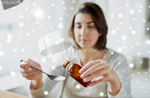 Image of ill woman pouring medication from bottle to spoon
