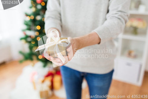Image of close up of man with christmas gift at home