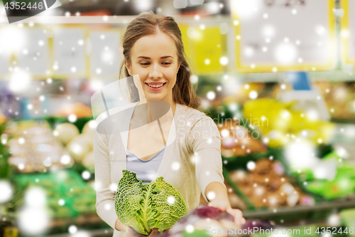 Image of happy woman buying savoy at grocery store