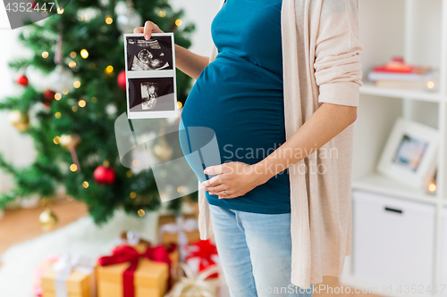 Image of pregnant woman with ultrasound images at christmas