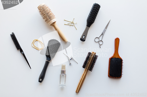 Image of scissors, hair brushes, clips and styling spray