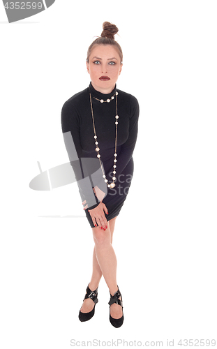 Image of Woman in black dress standing.