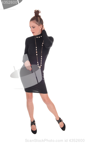 Image of Woman in black dress standing.