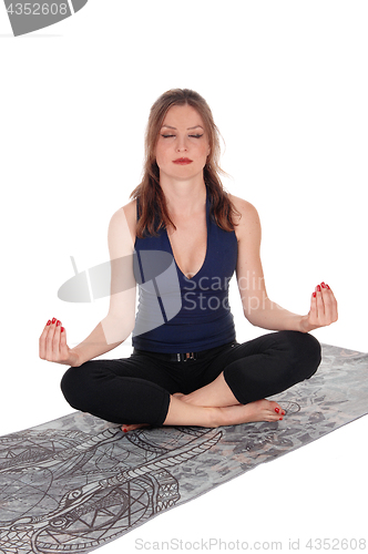 Image of Woman sitting on floor in yoga position.