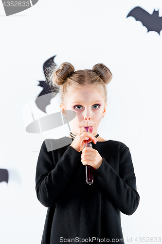 Image of Little girl witch in black dress over magical accessories. Halloween, the studio evening.