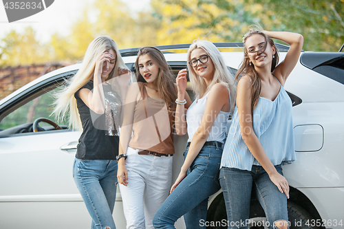 Image of The young women standing near the car