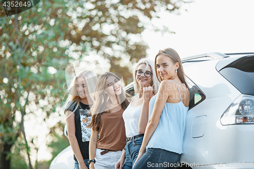 Image of The young women standing near the car