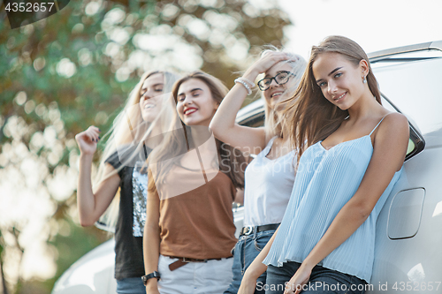 Image of The young women standing near the car